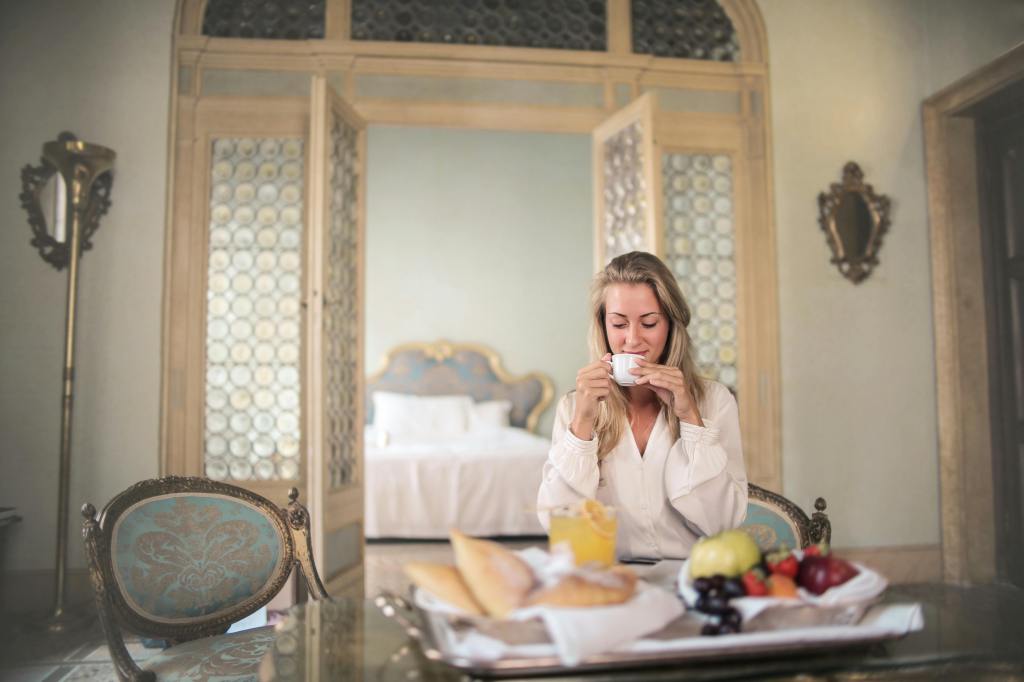 Vrouw drinkt koffie tijdens ontbijt in accommodatie