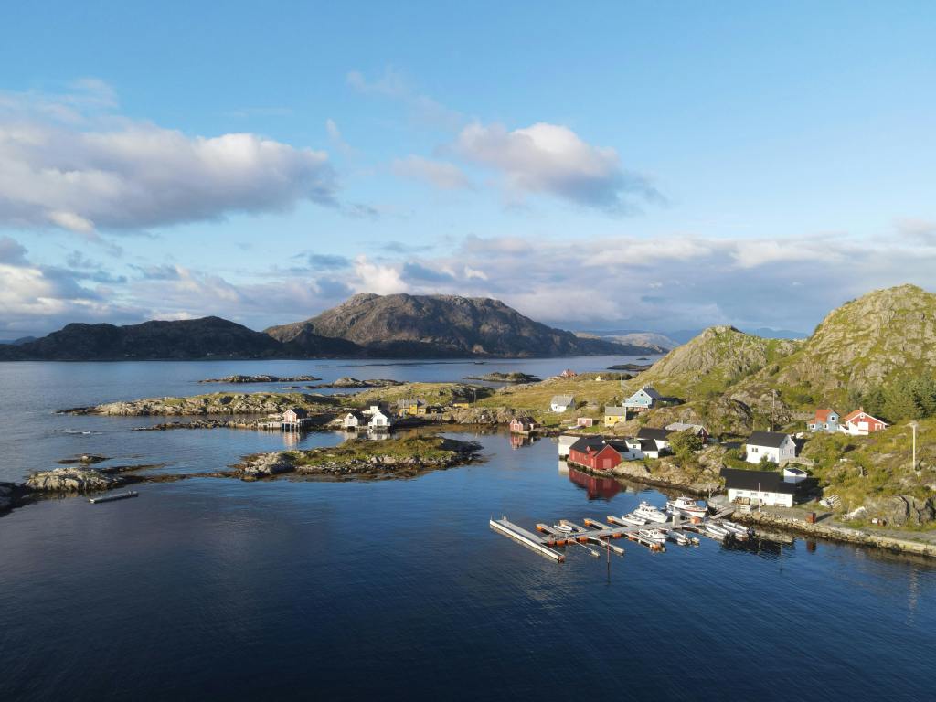 Noorse huizen aan meer met bergen op de achtergrond