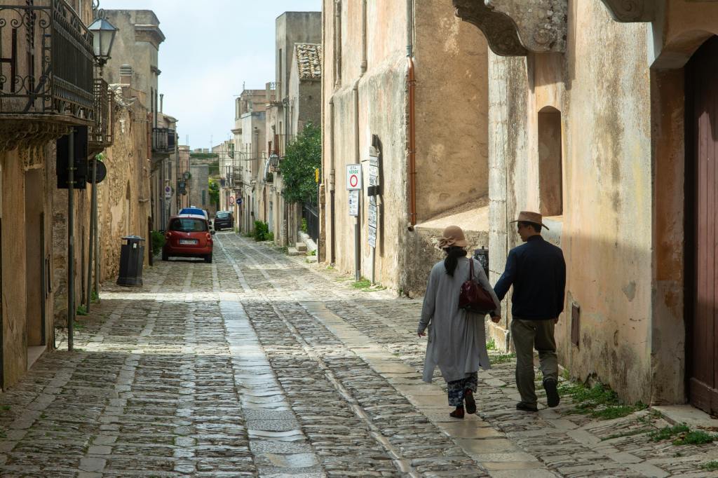 Koppel loopt door Italiaans straatje in Sicilië
