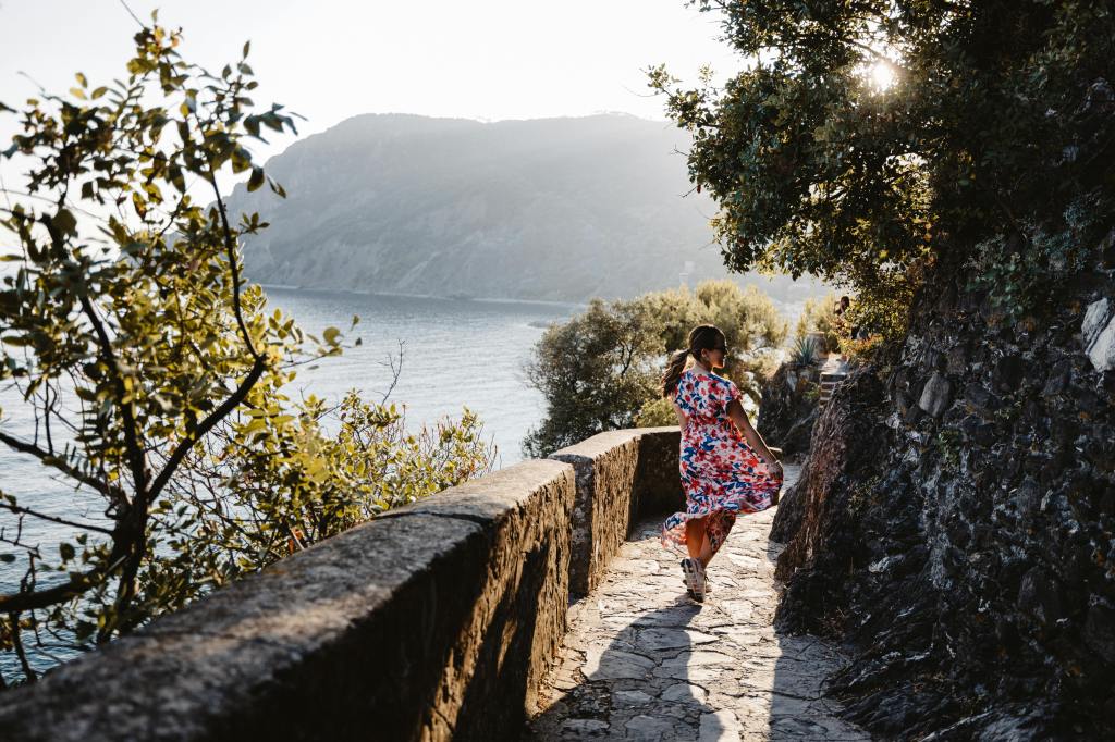 Vrouw loopt over pad langs de kustlijn in Italië